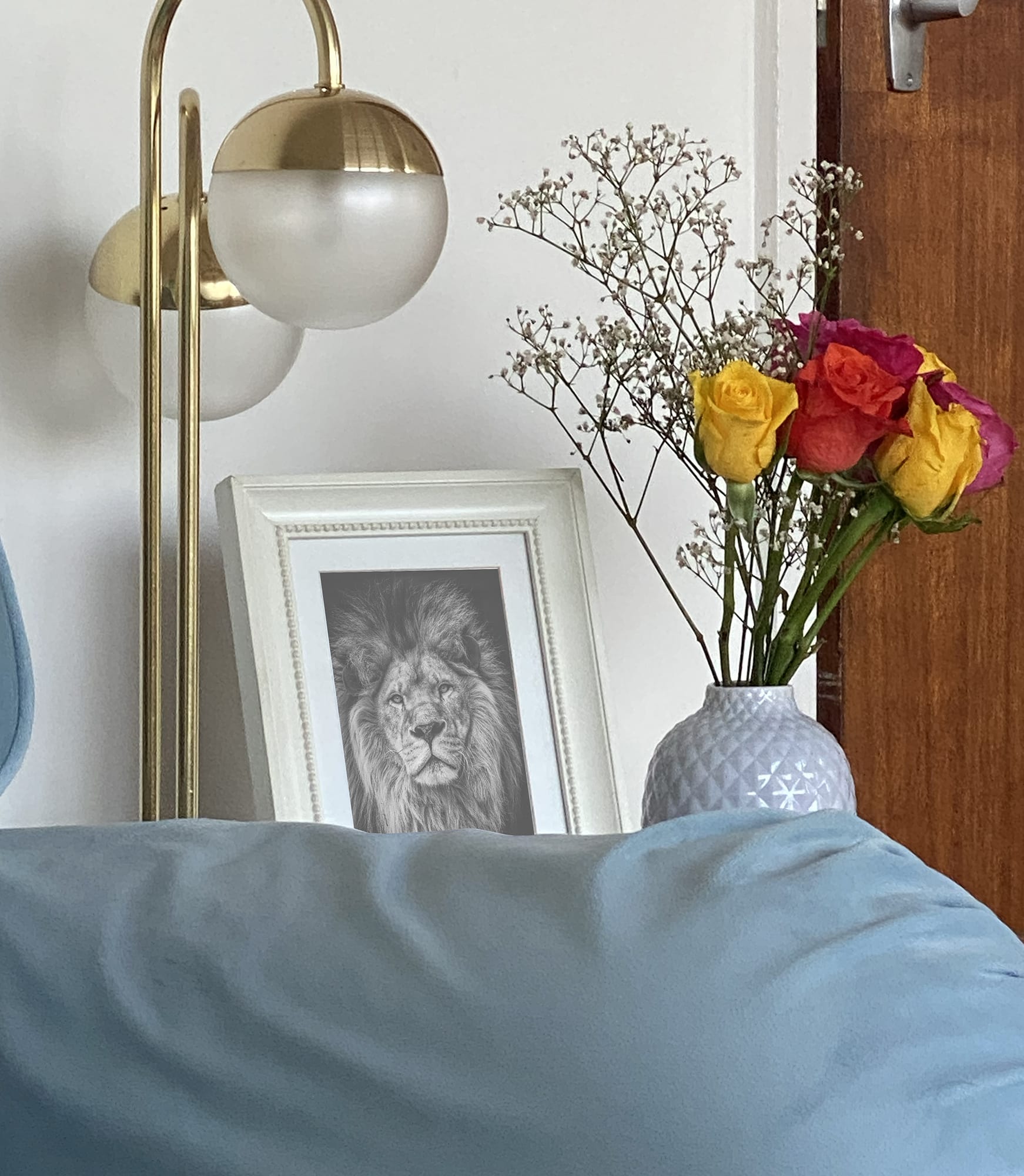 White vase with roses and a picture of a lion